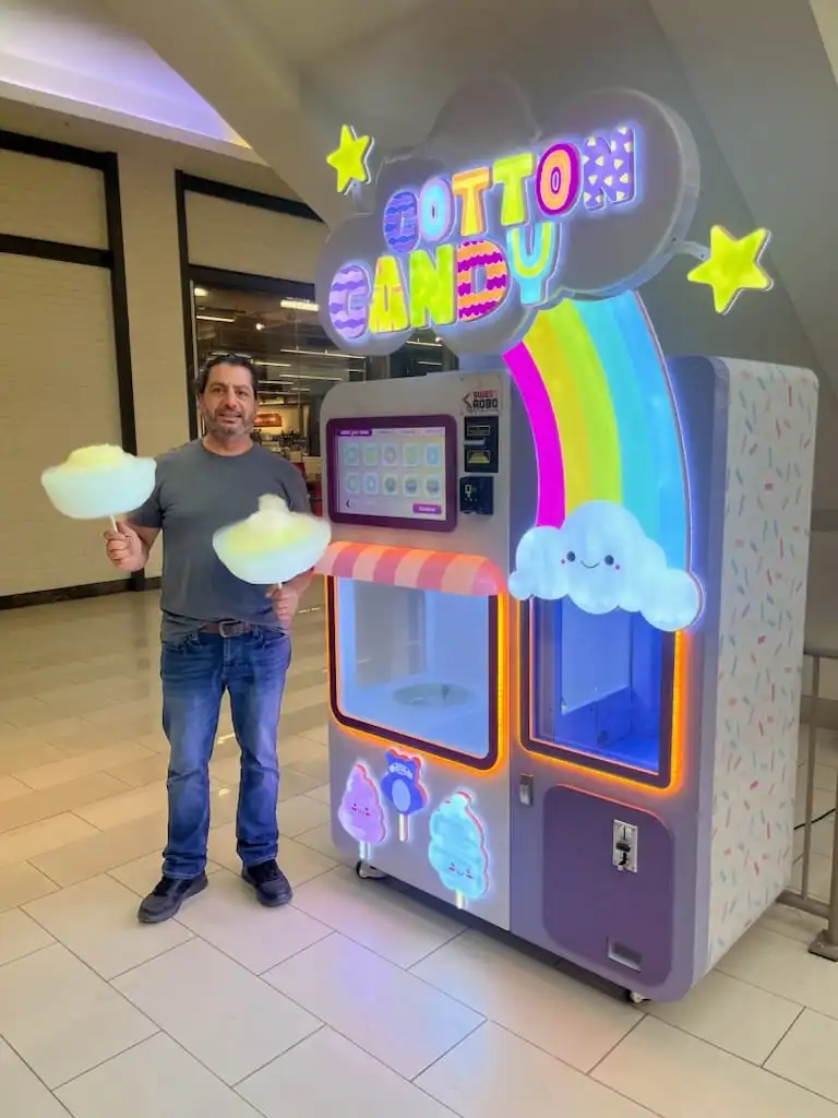 Man posing with two cotton candy creations